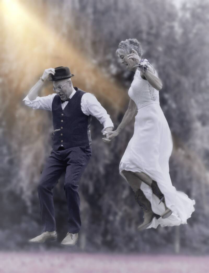 Bruidspaar springt samen door kleurpoeder – creatieve trouwfotografie