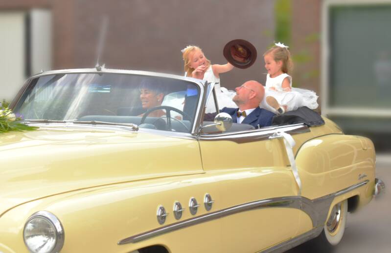 Bruidspaar in oldtimer met kinderen – trouwfotografie met retro touch