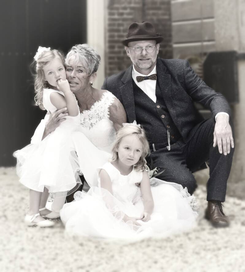 Bruidspaar en kinderen samen op bank – liefdevol familieportret