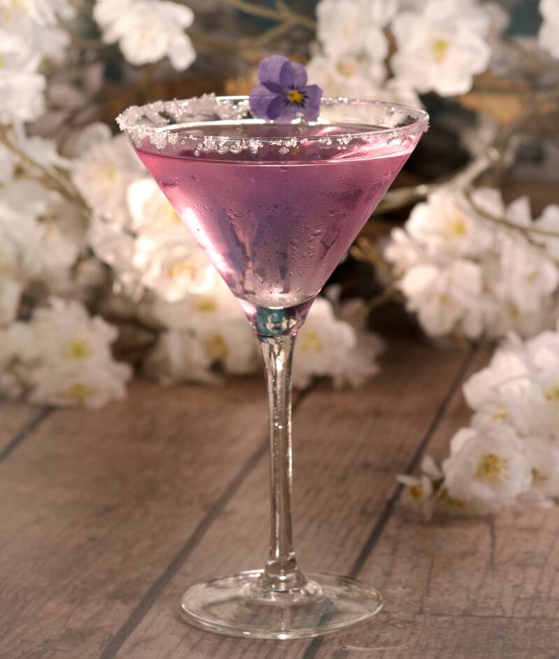 Paarse cocktail in martiniglas met bloemetje – drankfotografie met sfeer