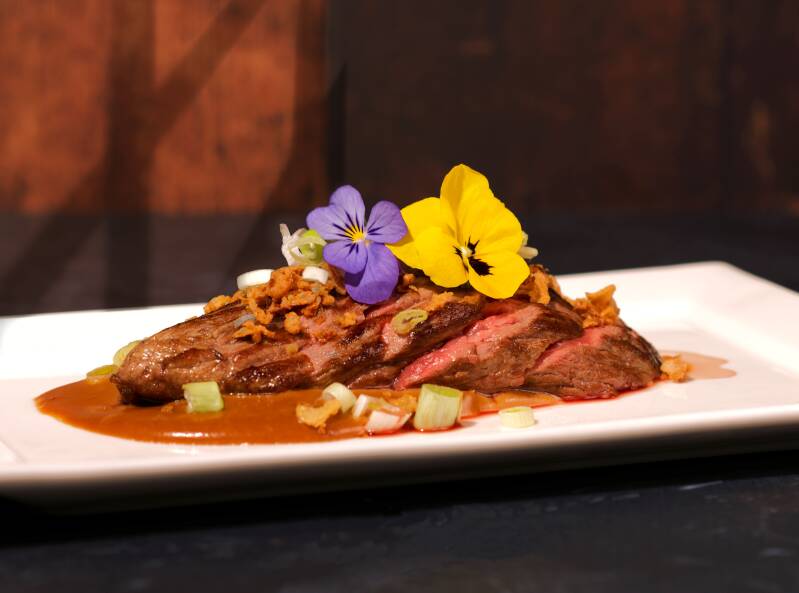 Vleesgerecht met eetbare bloem en saus – culinaire productfoto