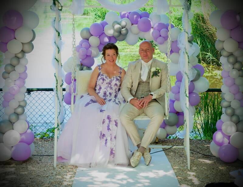 Bruidspaar zittend op schommel met ballonnen – creatieve trouwfoto