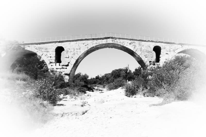 Oude stenen brug in zwart-wit – historische architectuur in ruige natuur