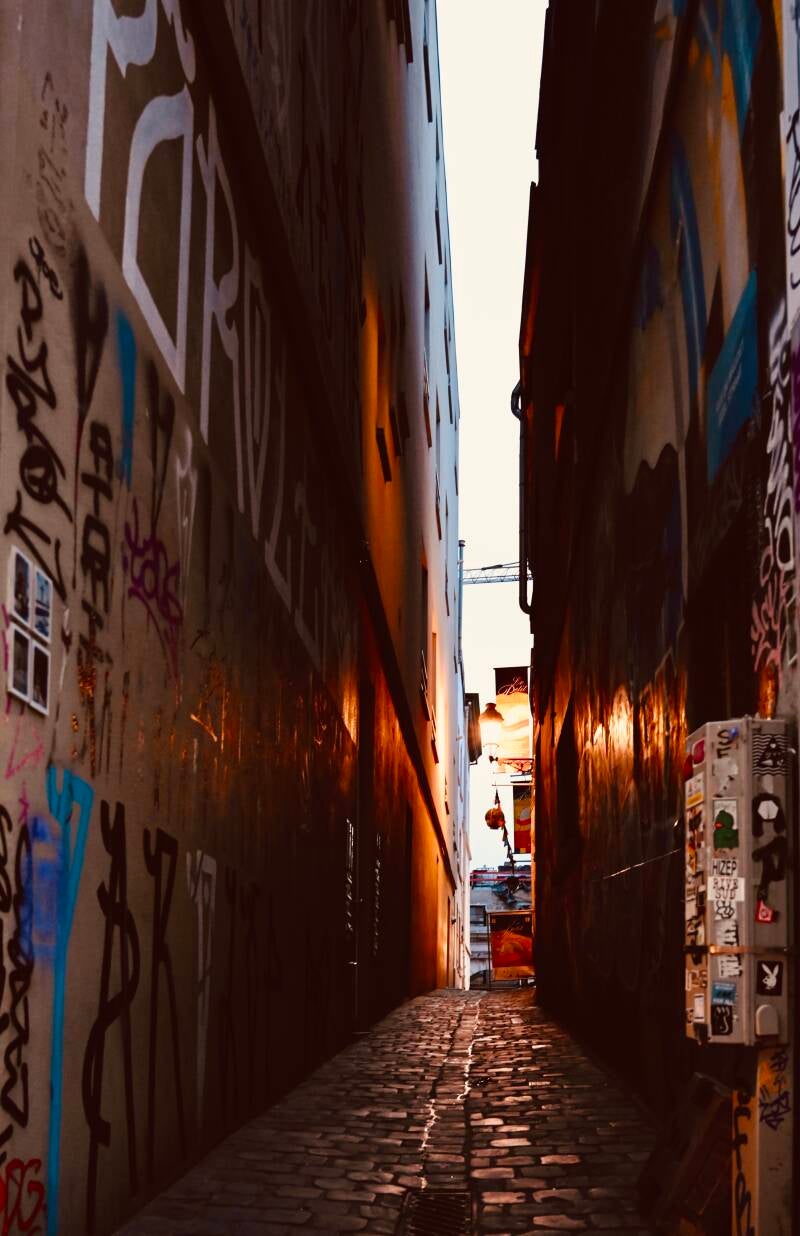 Smalle steeg bij ondergaande zon – urban streetfotografie met graffiti