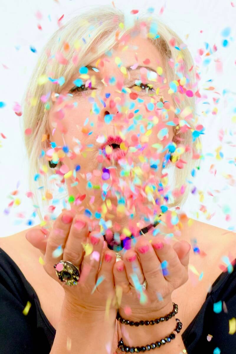 Kleurrijke confetti in het gezicht geblazen – creatieve portretfotografie met speels karakter