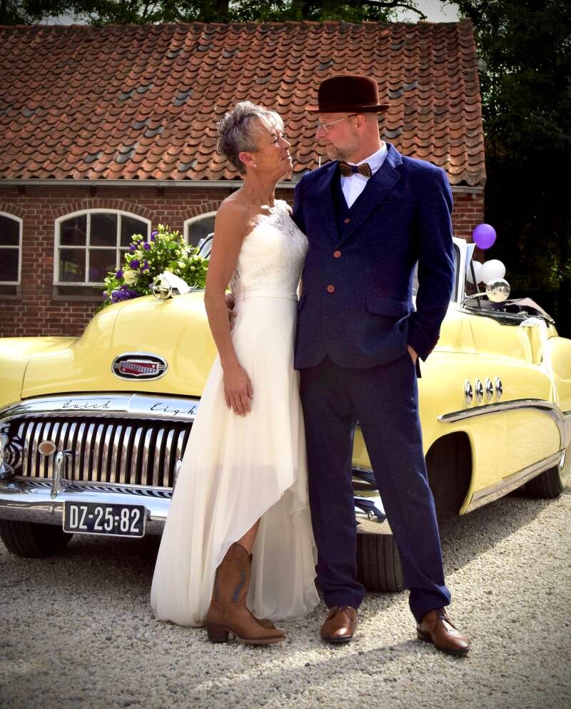 Bruid met bruidsboeket voor oldtimer – romantische bruiloftsshoot