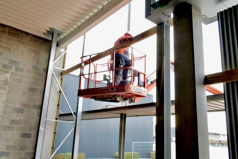 Bouwvakker in hoogwerker bij gevelbekleding – werffotografie