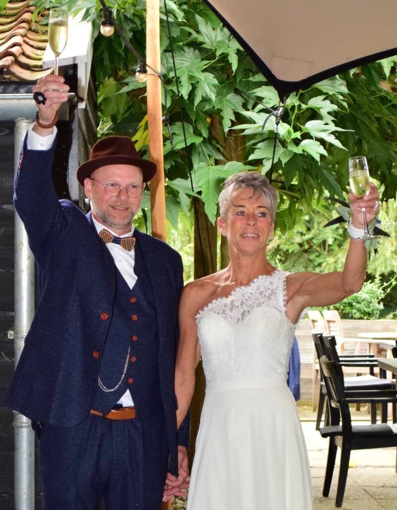Bruidspaar viert feest onder parasol – spontane huwelijksmomenten