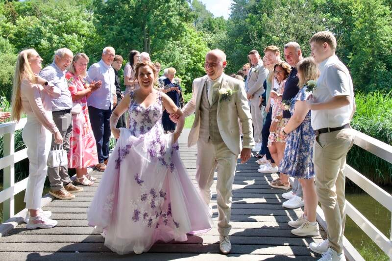 Bruidspaar loopt over brug met familie – spontane trouwreportage