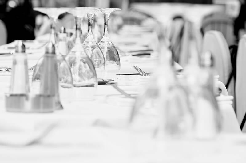 Wit gedekte tafel in close-up – zomers terras met drinkglazen