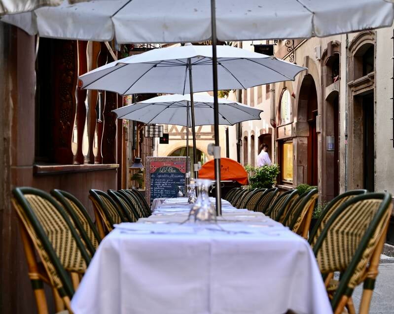 Gedekte tafels onder parasols – sfeervol restaurant in avondlicht