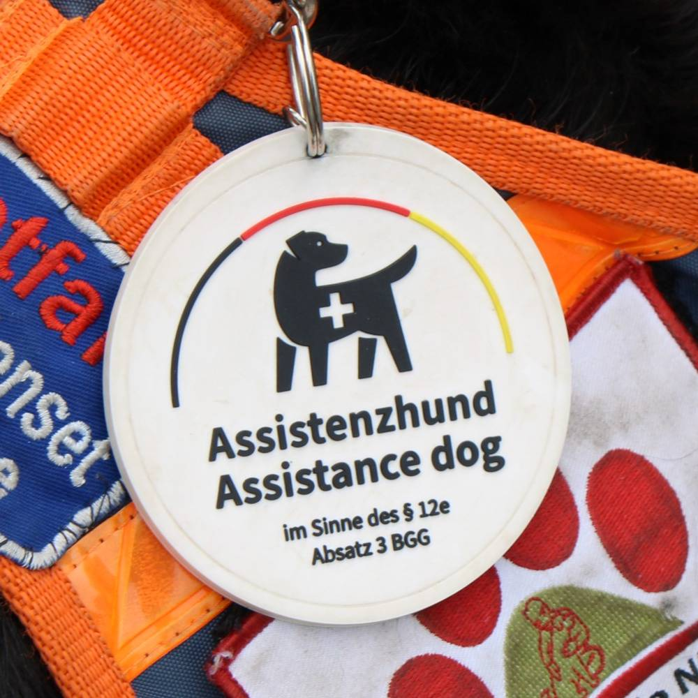 Zu sehen ist die offizielle Plakette die ein staatlich geprüfter Assistenzhund verliehen bekommt.