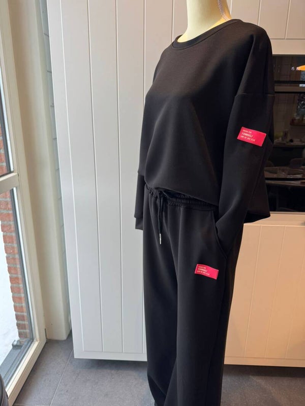zwart huispak met roze label