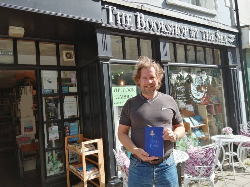 The author holding a copy of The King's Pride outside The Bookshop by the Sea.