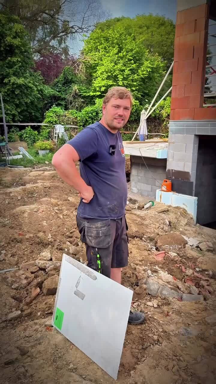 Ruwbouwwerf in Dilbeek, met een man naast de woning.