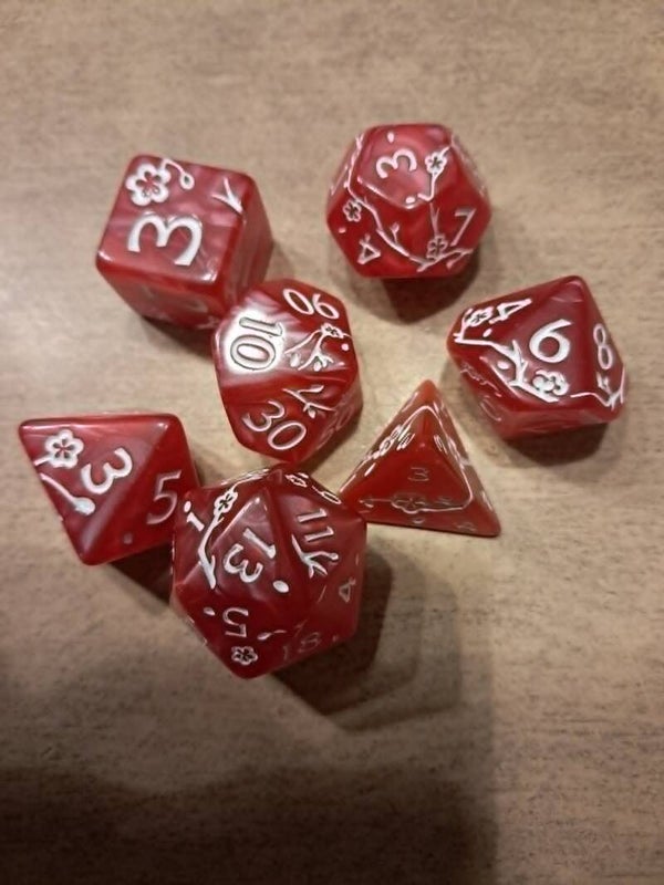 Red d&d dice with white blossom