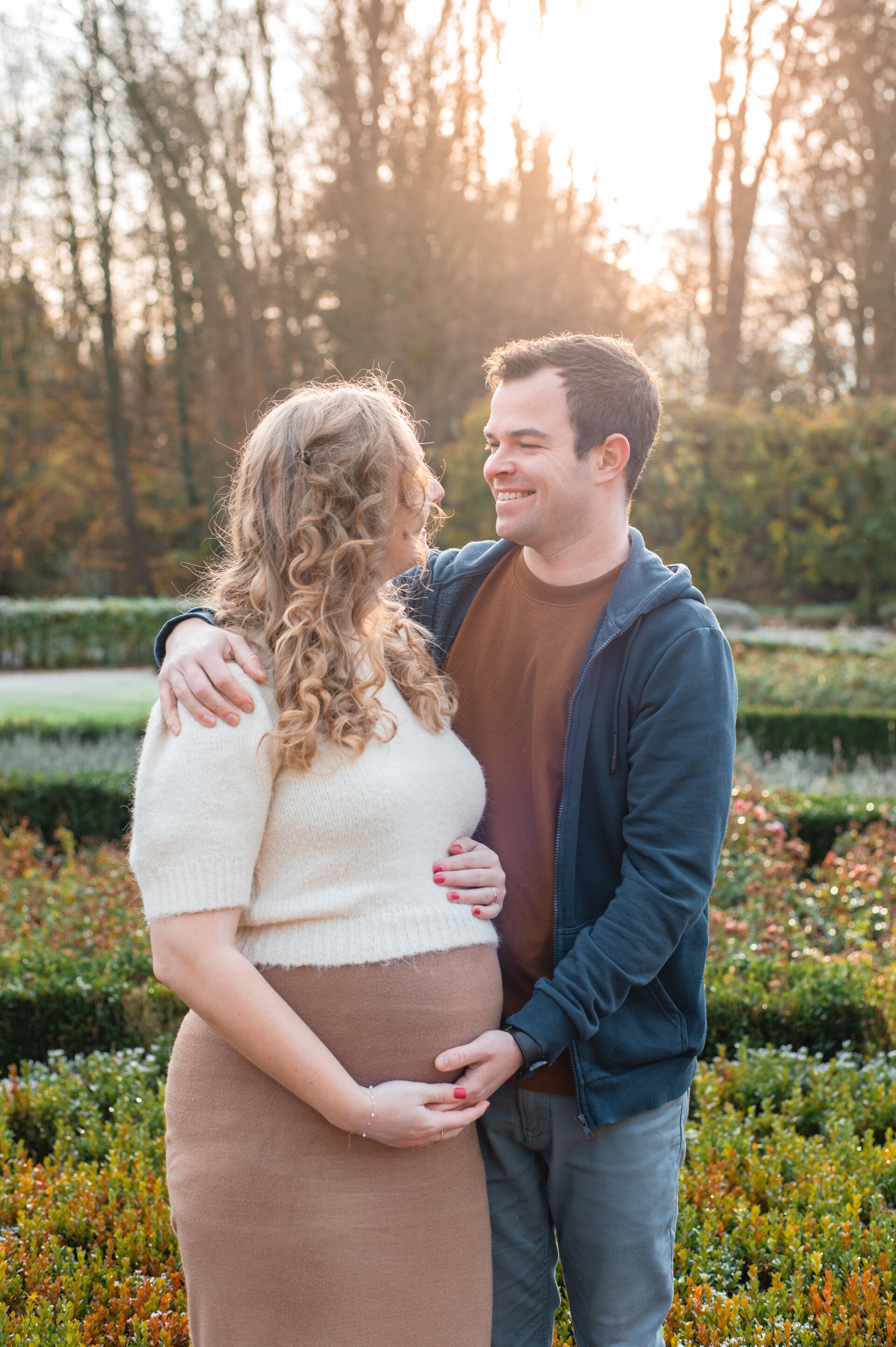 Buiten zwangerschap fotoshoot in Limburg bij zonsondergang – aanstaande moeder in zachte tinten