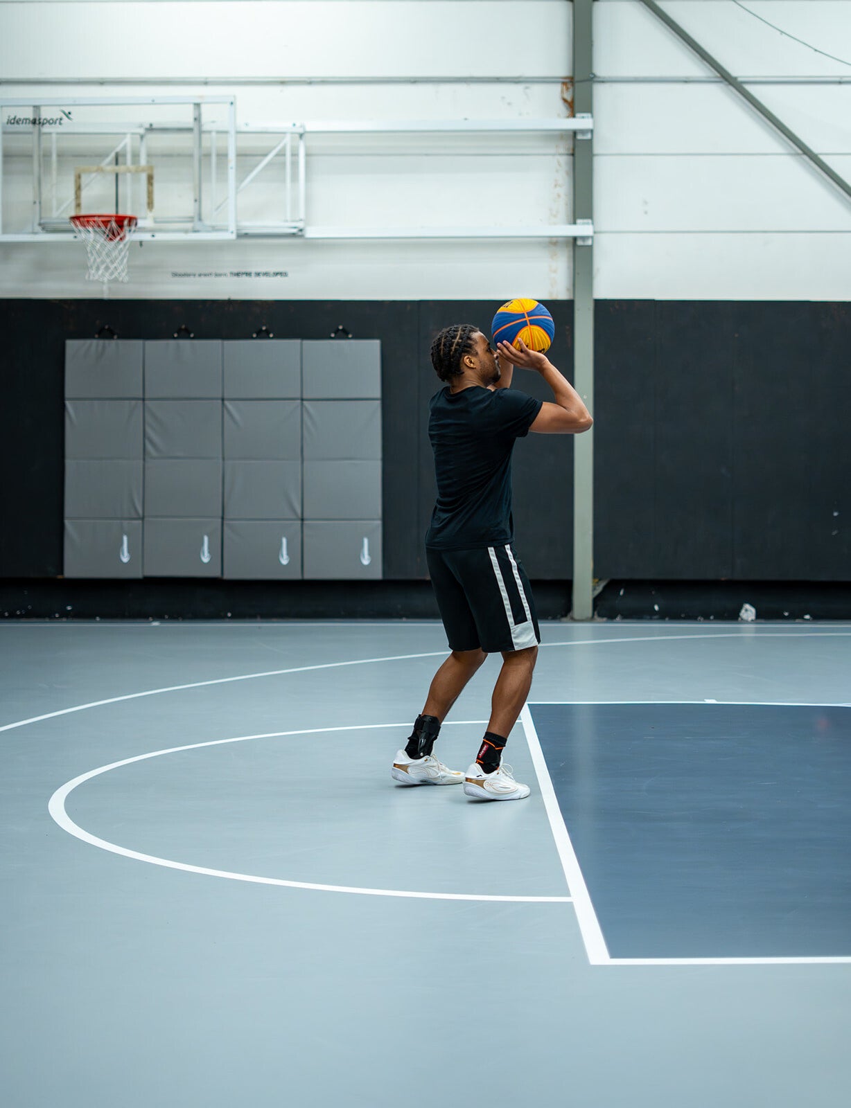 Basketbalspeler neemt een schot op het indoor half court van The Facility Merksem