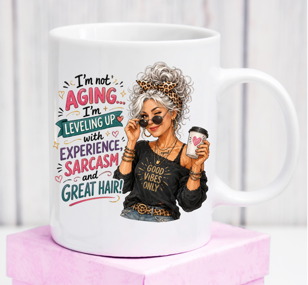 Cană premium „I’m Not Aging, I’m Leveling Up” – cadou amuzant pentru femei care îmbătrânesc cu stil