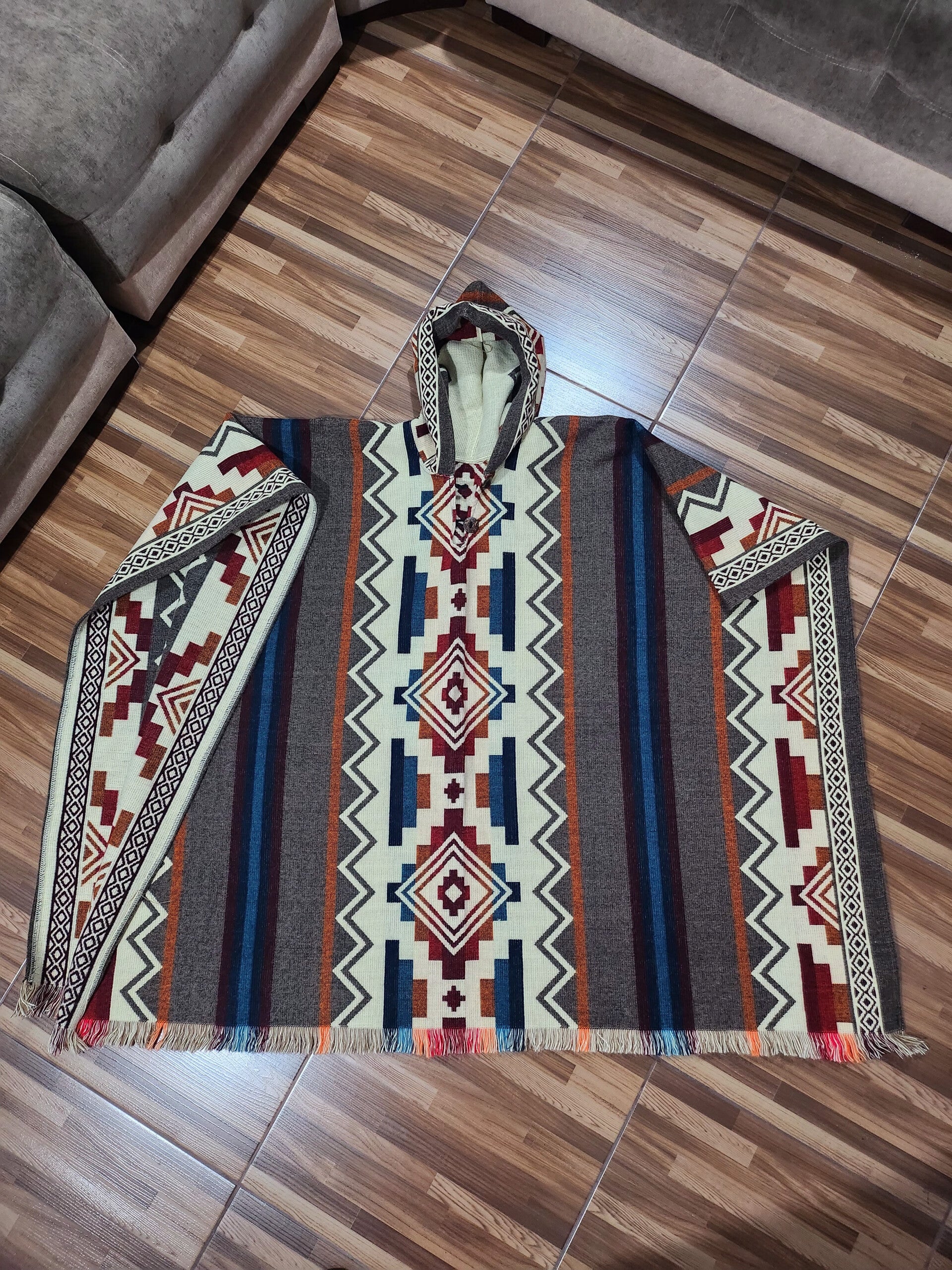 Alpaca poncho, dark and light brown colors, light blue stripes, zig zag design on the sides. / Poncho de alpaca, colores cafe obscuro y claro, rayas azul claro, diseño de zig zag en los laterales