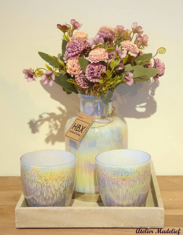 Vaas met kunstbloemen en theelichtjes op schaal.