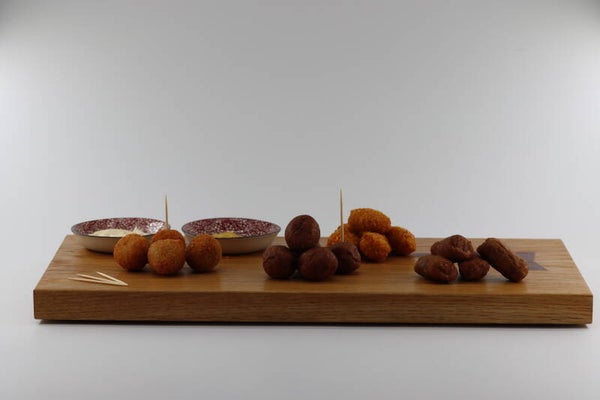 Hapjes, borrel of tapas serveerplank gemaakt van eikenhout met twee porseleinen schaaltjes