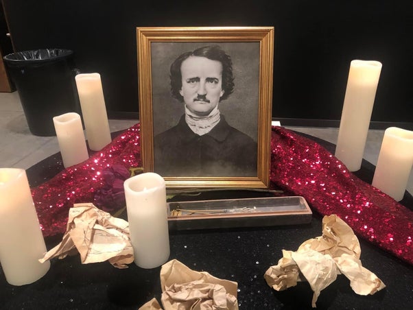 Photo og Edgar Allen Poe, with candles around g it.