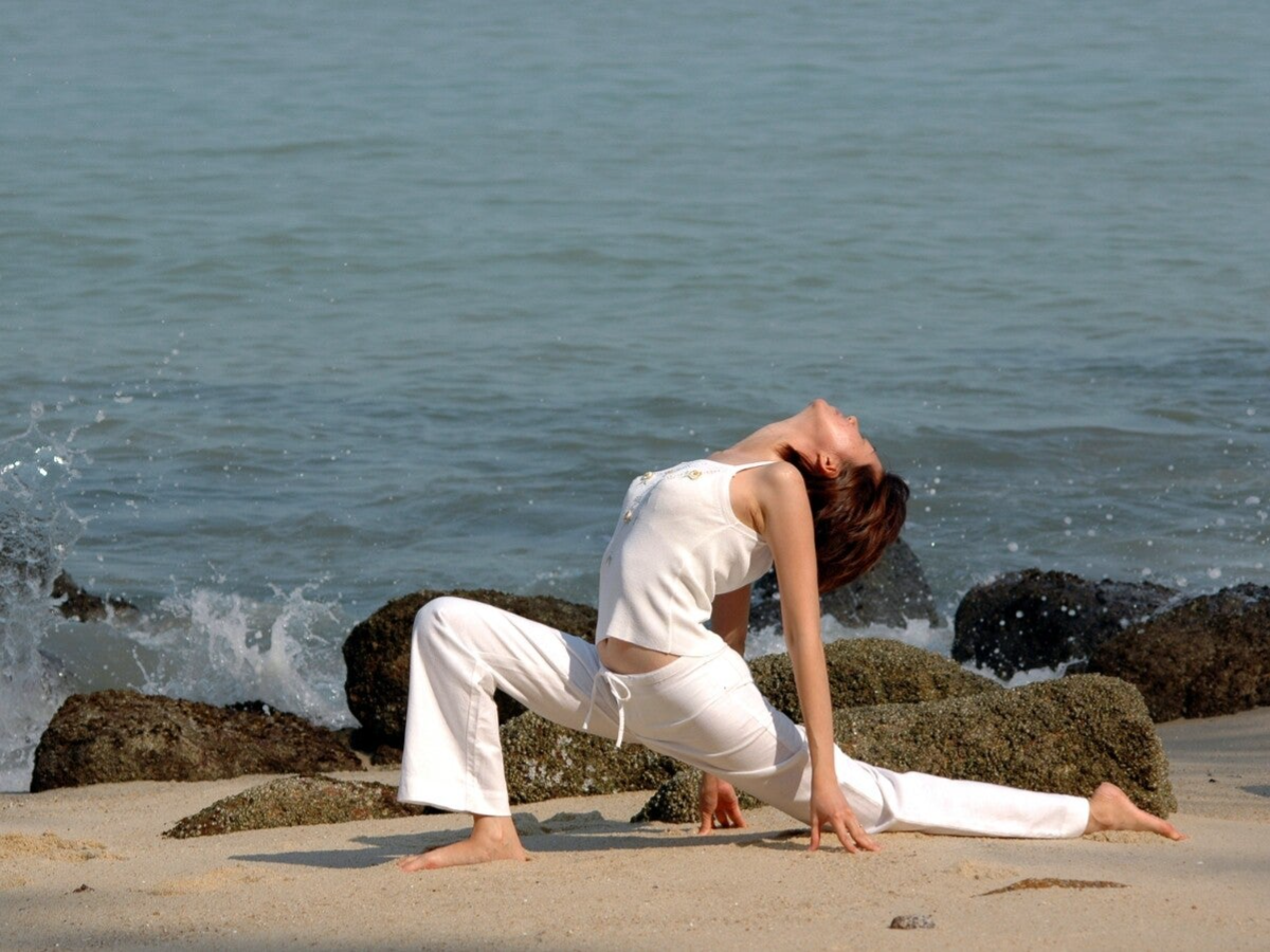 Femme en posture de yoga face à la mer sur la Côte d'Azur