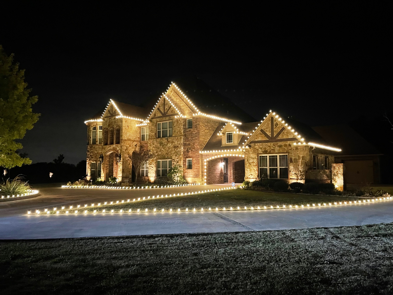 Professional warm white Christmas light installation outlining a luxury Fort Worth home at night