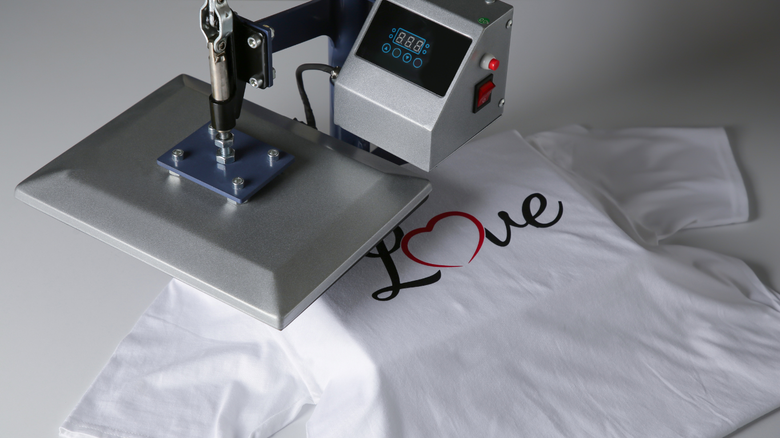 This is an image a heat press maching pressing a shirt with the word LOVE.
