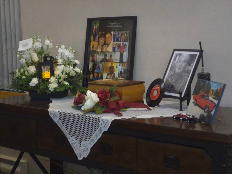 Memory table with photographs, flowers and candles at a celebration of life in North Bay, Ontario