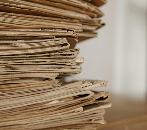Stack of historical documents representing British Army service records and WW1 Medal Index Cards