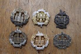WWI Essex Regiment insignia laid out on wood – guide to researching First World War service records