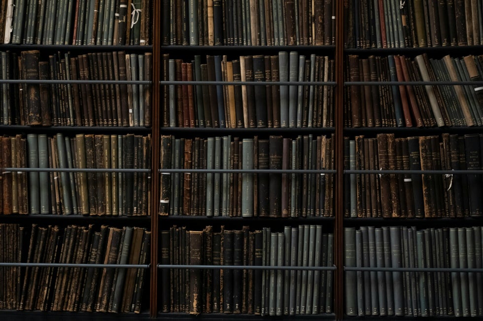 Bookshelves filled with historic volumes – representing records held in regimental museums and county archives