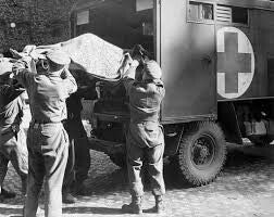 Royal Army Medical Corps personnel loading a casualty into a field ambulance during the Second World War.