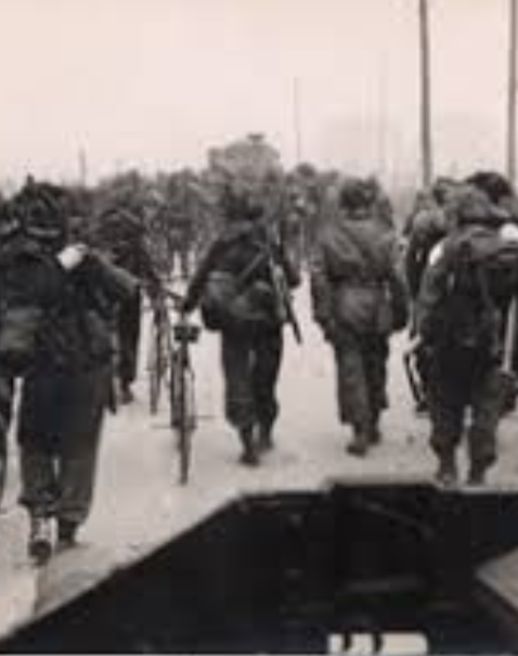WWII British soldiers marching with rifles and bicycles, ideal for military records search and tracing service history