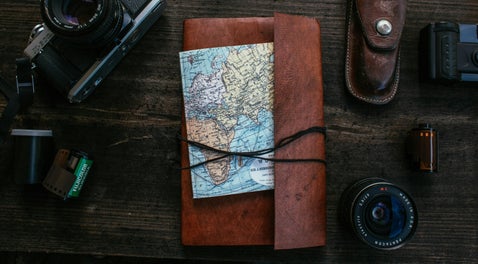Leather-bound journal and map representing the process of tracing UK war records and soldier diaries