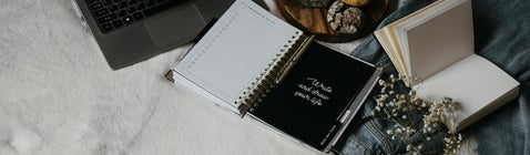 Modern workspace with notebook, laptop and open journal, representing how to use war diaries, medal rolls and casualty lists in military research
