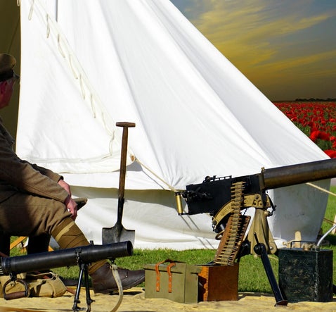 Reenactor in British Army uniform beside war tent, used to explain multiple WW1 service numbers in UK military research