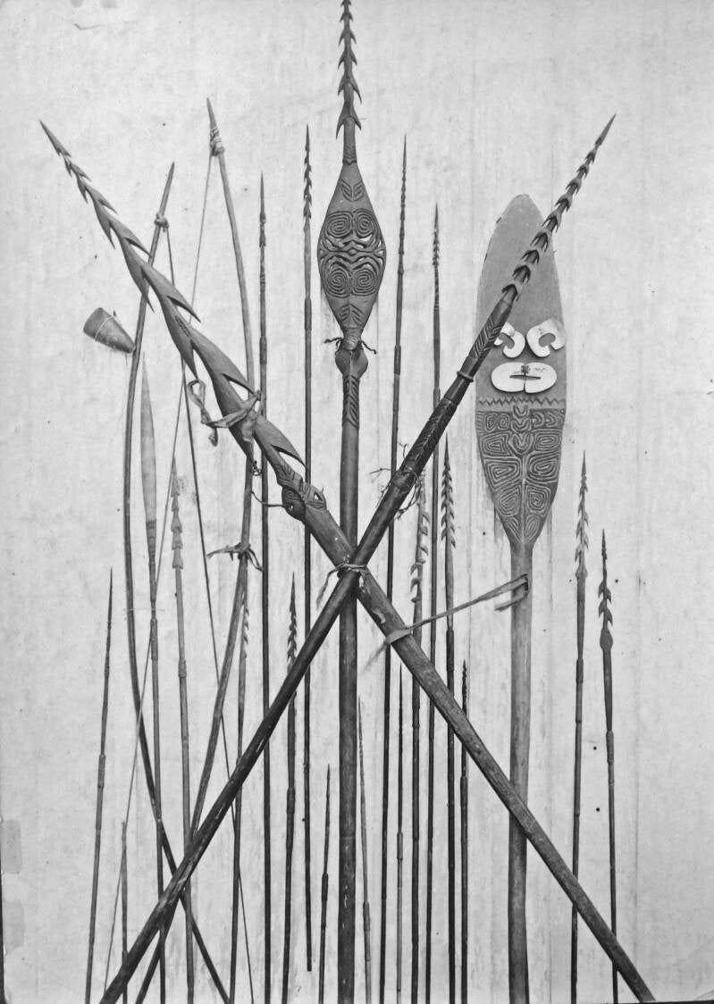 Vroeg verzamelde Asmat etnografica 10210 Doos 3  -  Speren pijlen en een bewerkt pagaaiblad met enkele neusschelpen aangehangen - Oetoemboewee-rivier 1906 - 1