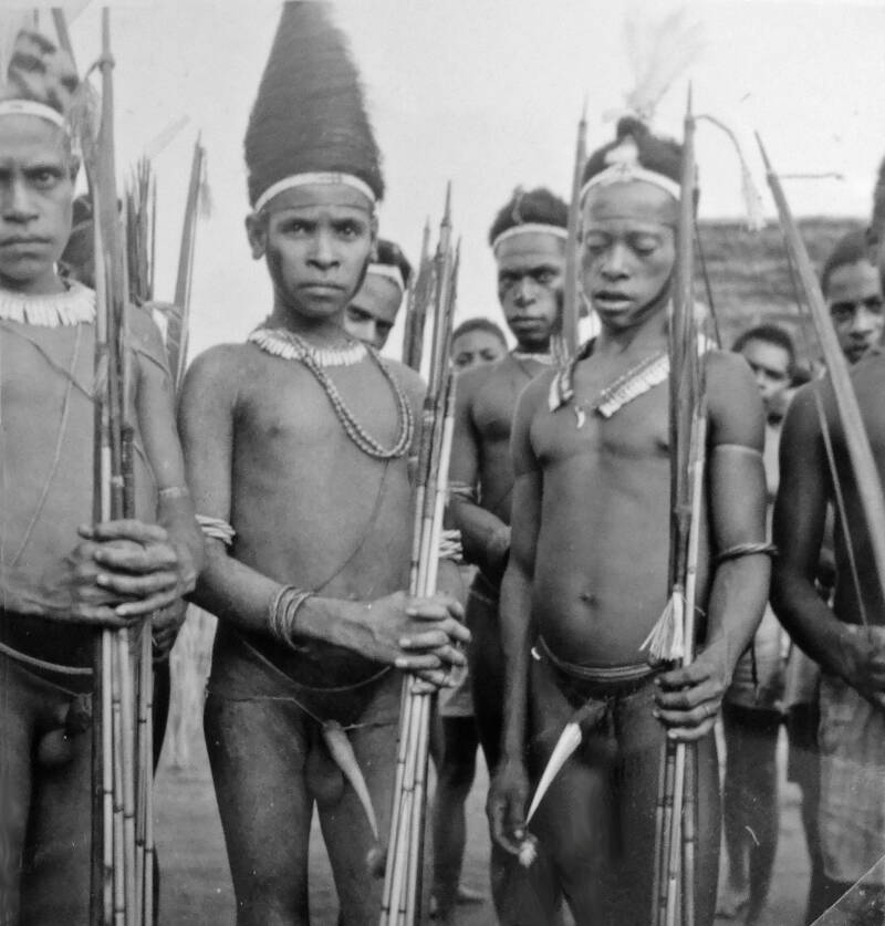 20213 Serie BI-184 Mandobo jongelingen in feestkleding te Mindiptana Juli 1951