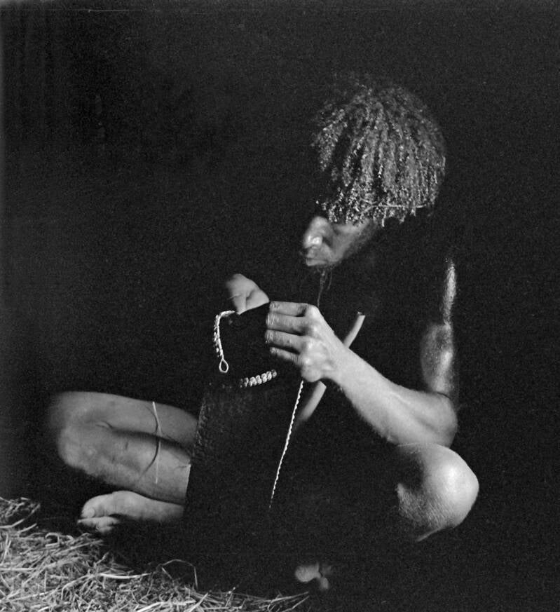Donkers album2film130foto001 Ndani bezig met de vervaardiging van een wopok of walimo en ook wel Ndani-stropdas genoemd
