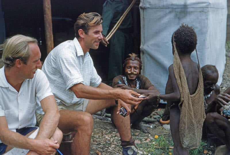 terLaag-209-2-115 Jan Sneep en Wim Herberts-Foto Piet ter Laag: Wim Herberts overhandigt een luciferdoosje aan een kleine Sibiljongen - Ngalum