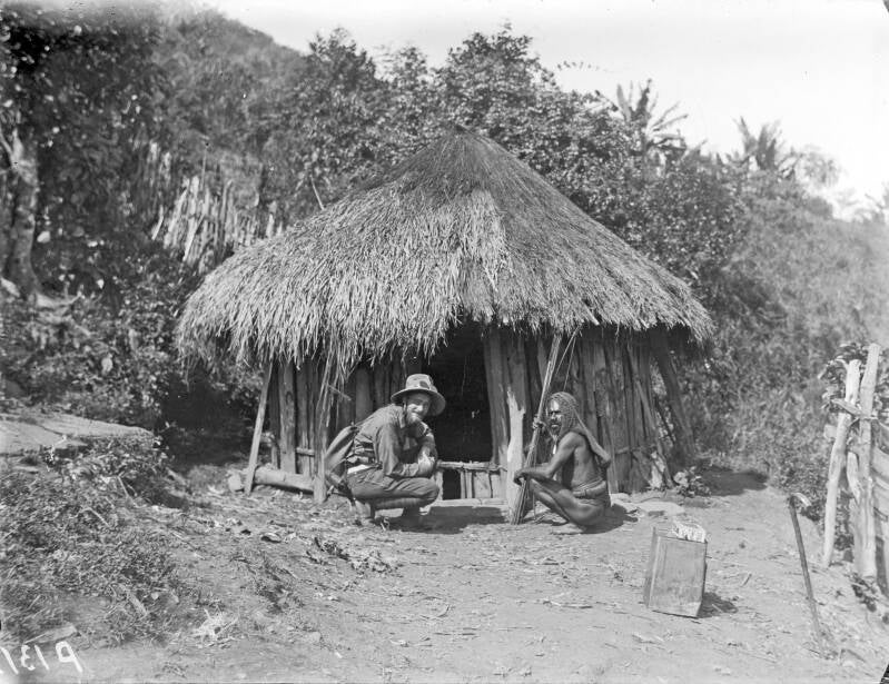 TM-10010057 Een Papoea met een expeditielid voor zijn hut in de Swart-vallei Jan Jongejans 1920-1921