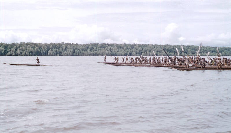 Bisj ceremonieel Sjoeroe (Sjuru; Syuru) 1956/1957-  Asmat 23 In de verte nadert nu als een compacte massa over het water de prauwenvloot 