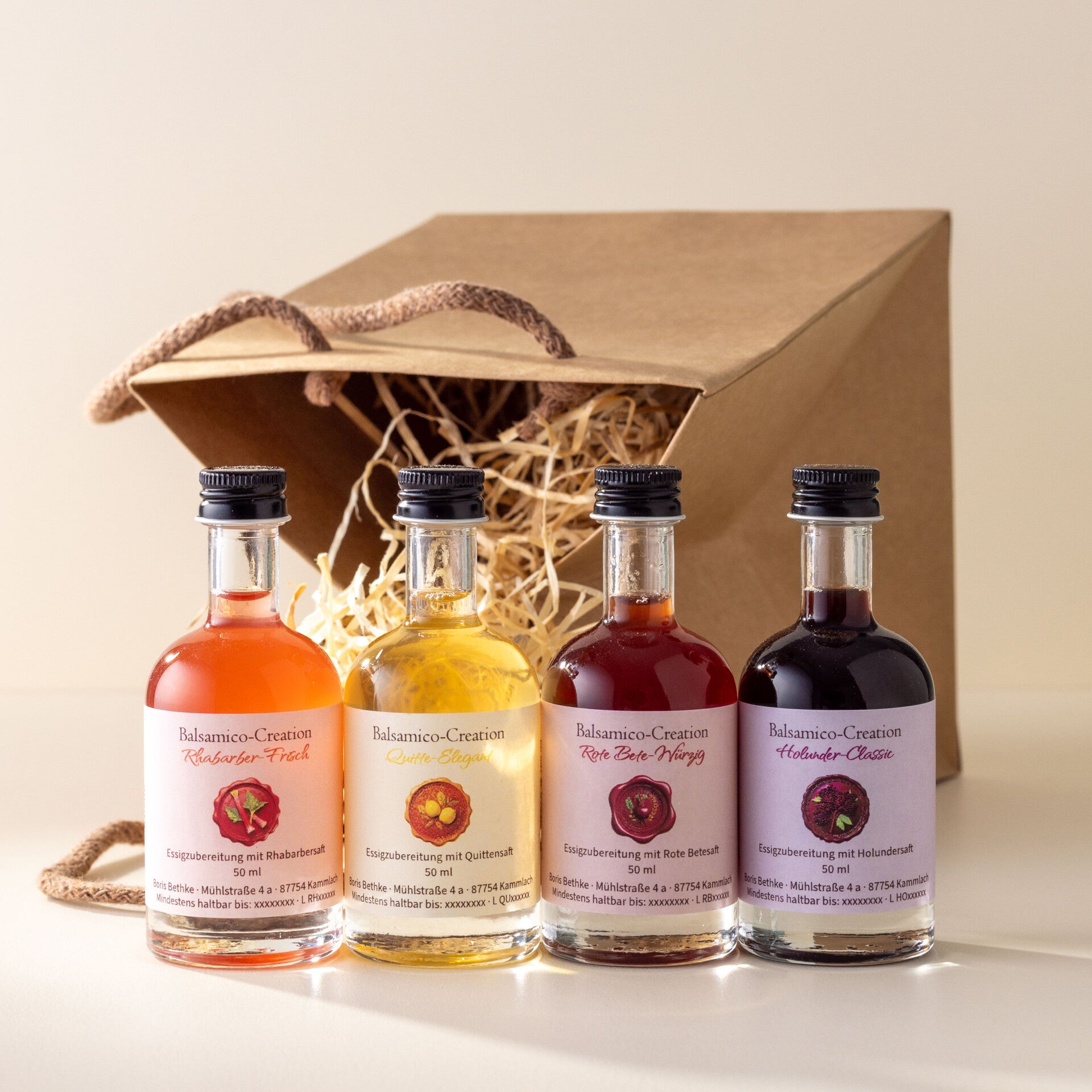Vier Balsamico-Creationen der Manufaktur – Rhabarber, Quitte, Rote Bete und Holunder – in Glasflaschen mit Hangtags