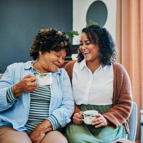 Smiling senior and Caregiver Enjoying coffee during respite services