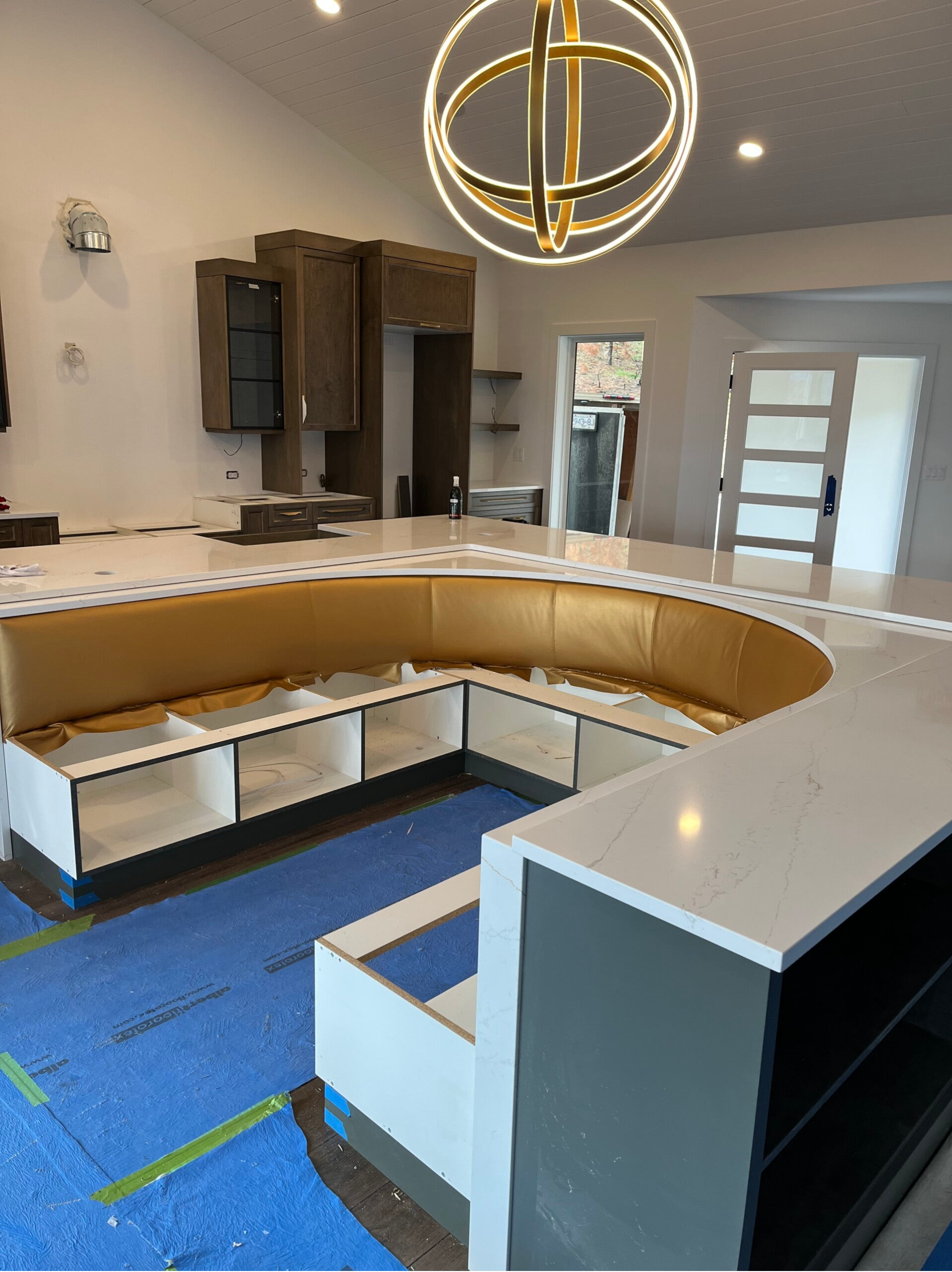 Custom quartz countertop with curved banquette seating, kitchen under construction