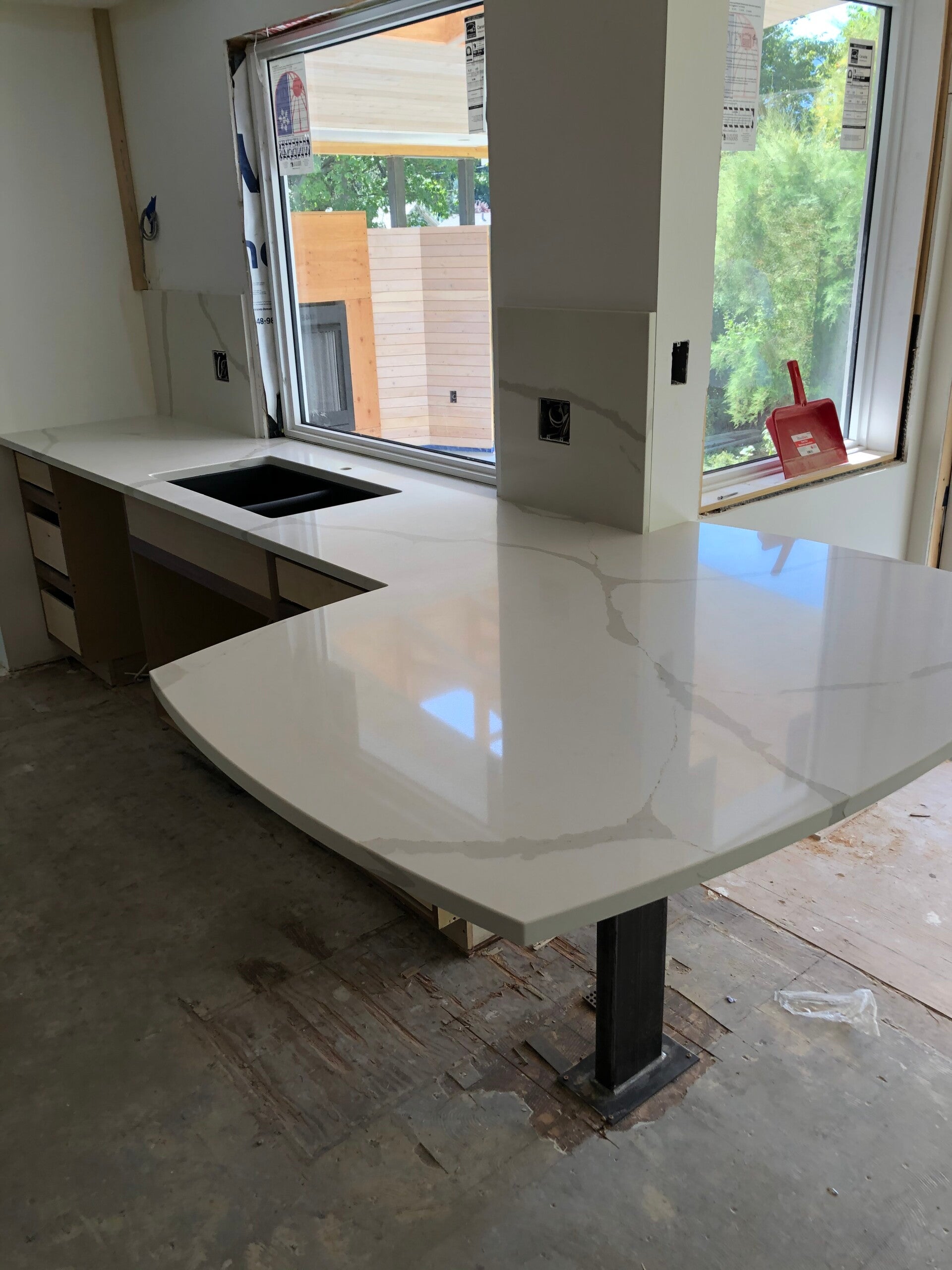 Custom curved white quartz countertop with sink cutout, kitchen design