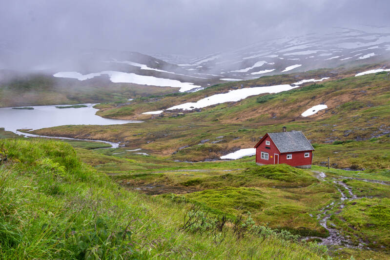 Norwegen Vikafjellet Landschaftsroute Rote Hütte Nebel Schneefelder
